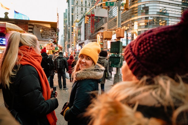 Three friends walk around New York City in the wintertime.