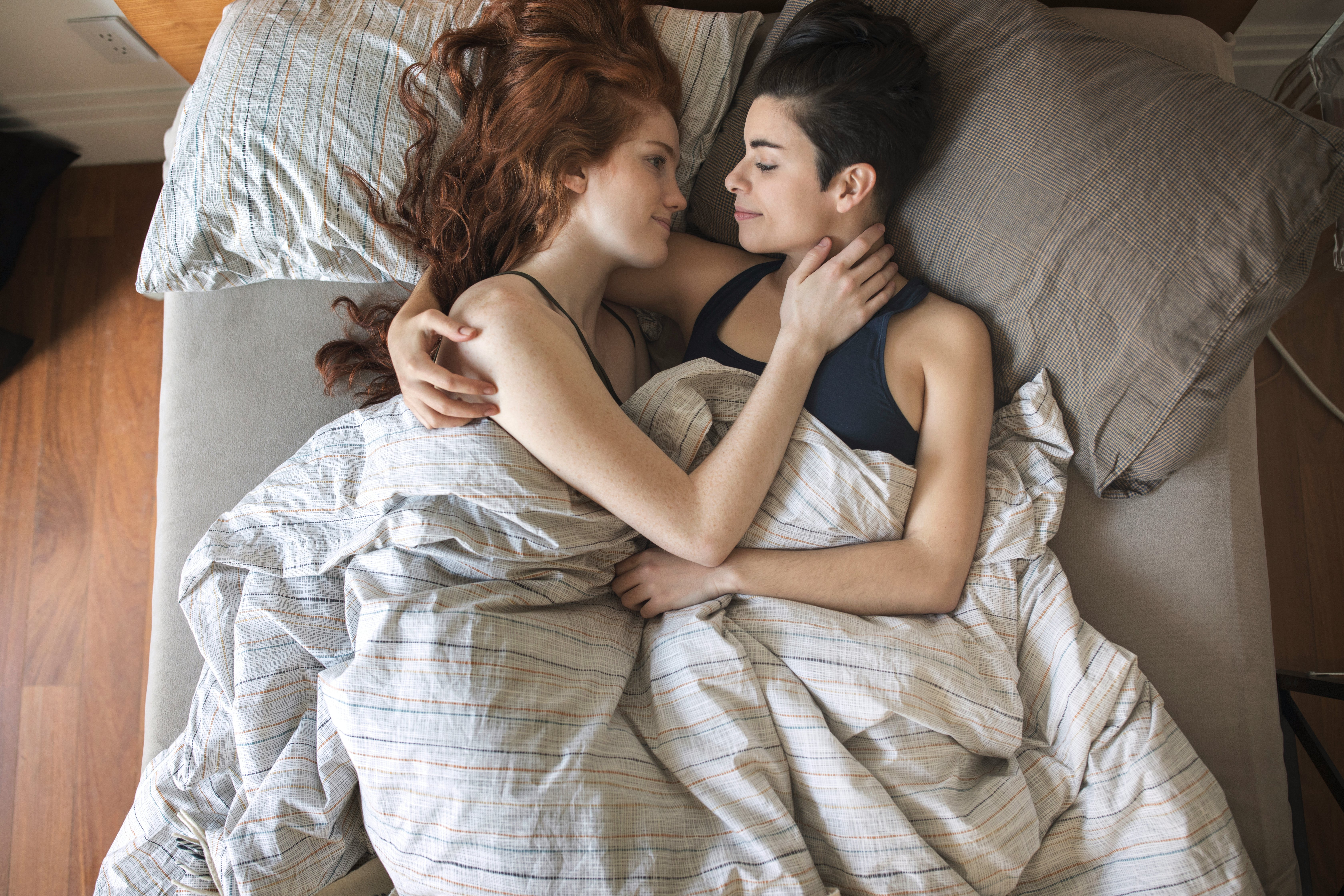 Lesbian Couple Talking In Bedroom Stock Photo