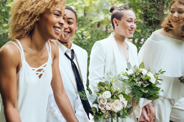 A group of four women hang out at a backyard wedding.
