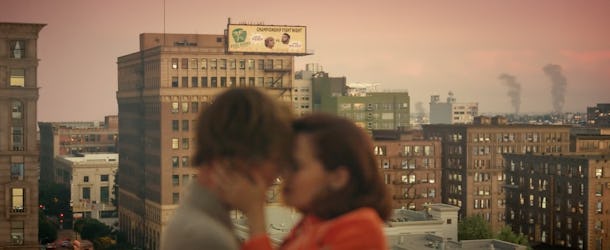 A young couple kiss on a rooftop in the city at sunset during Justin Bieber's "Anyone" music video.