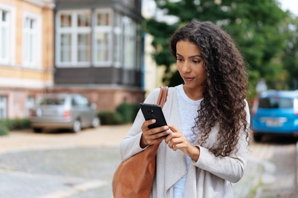 Young woman looking at phone at a text from someone who ghosted her