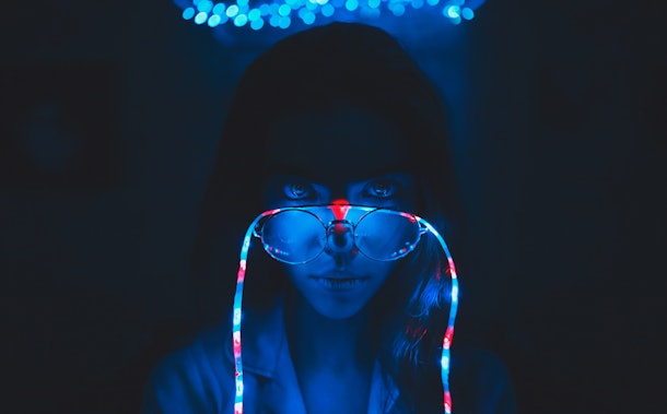 On the girl's glasses garland. Photo in dark blue