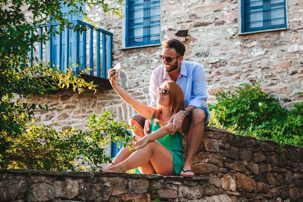 Young couple in love taking selfie in Greece on their honeymoon