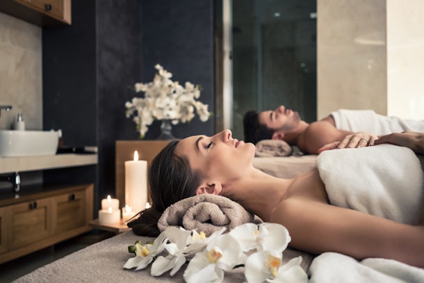 Young man and woman lying down on massage beds at Asian luxury spa and wellness center