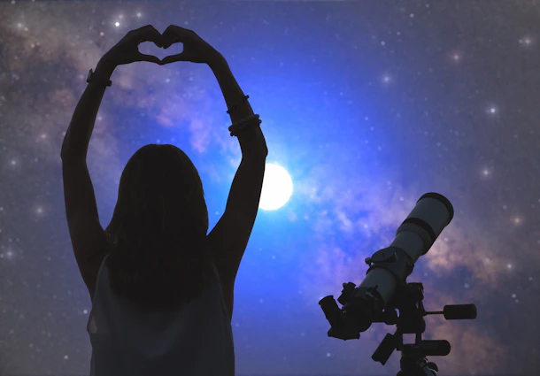 A woman makes a heart with her hands while stargazing at night.